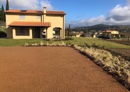 Pavimento drenante all'esterno di un'abitazione, con giardino e vista su colline, in un contesto residenziale.