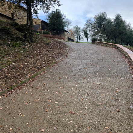 Rampa drenante di accesso a forte pendenza, in un contesto naturale autunnale con alberi e vegetazione.