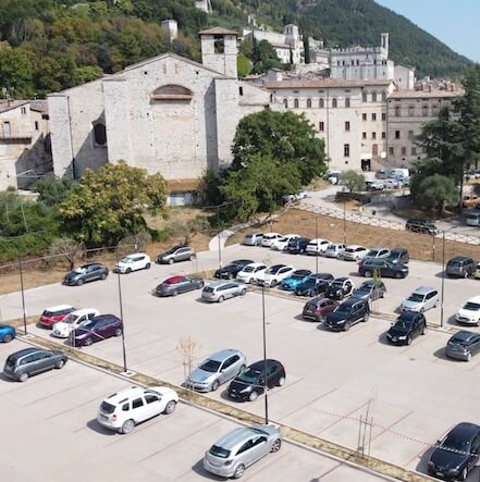 Parcheggio in calcestruzzo Drenidea nel centro storico di Gubbio, con l’ex Seminario e le case del centro storico sullo sfondo.